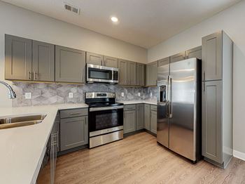 A kitchen with a stainless steel refrigerator and oven at Linc, Des Moines, IA  .